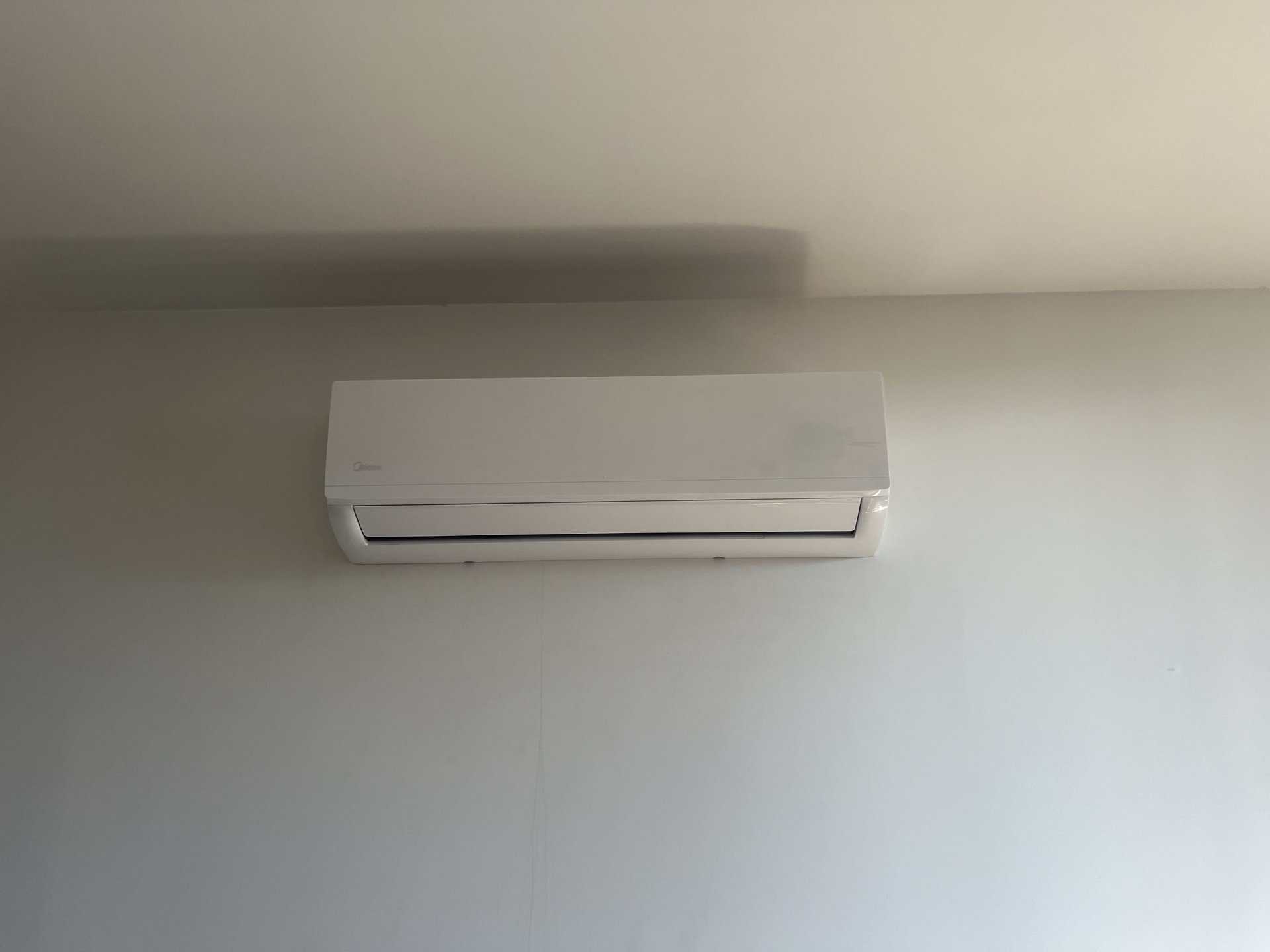 Air conditioning unit mounted on an interior wall inside a building.